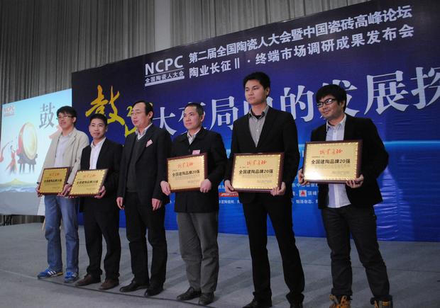 图3、pp电子游戏陶瓷荣获“天下建陶品牌20强”称呼，图为pp电子游戏品牌代表（左四）在接受颁奖情景